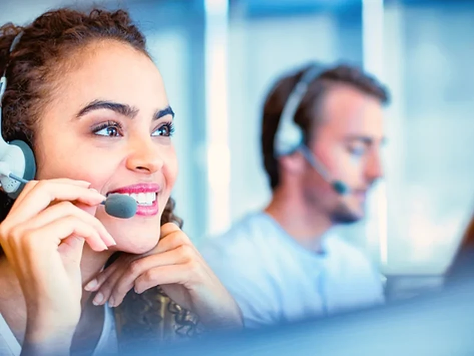 Call centre operators wearing headsets with microphones